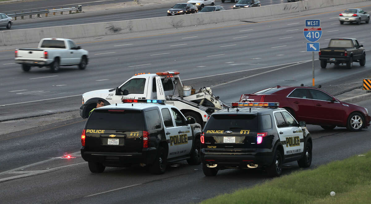 A Cadillac Seville is towed away Monday July 14, 2014 on the westbound Loop 410 access road after it struck a woman crossing lanes at about 4:52 a.m.. San Antonio police sergeant James Lint said a female passenger in the vehicle exited the car and crossed several lanes of traffic when the car looped back around on the highway and struck her. Lint said the people in the same vehicle were involved in a disturbance at a nearby apartment complex earlier. The woman died early Monday morning at University Hospital.