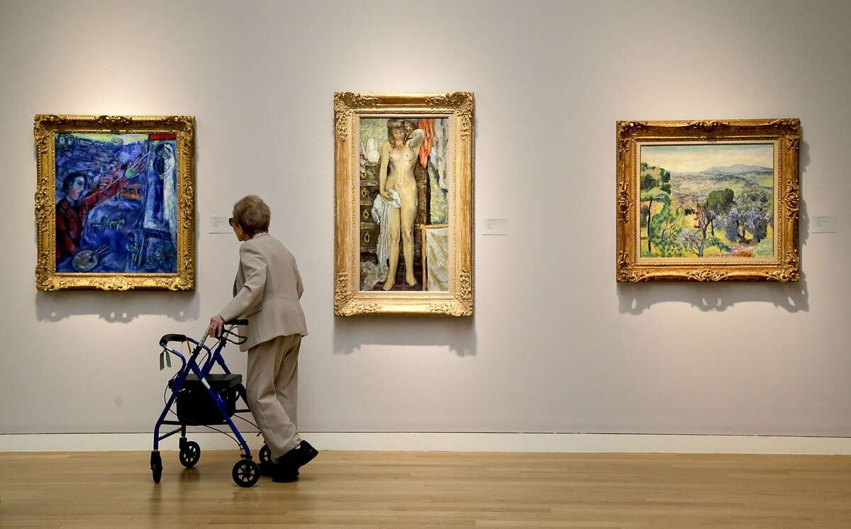 FILE - In this May 2, 2014 file photo, a woman browses various impressionistic paintings during a preview exhibition for Sotheby's Spring Evening Sale of impressionistic and modern art, in New York. EBay Inc. has partnered with Sotheby's to offer a new live auction feature on eBay's Web site and real-time bidding for auctions that are taking place at Sotheby's headquarters in New York. (AP Photo/Julie Jacobson, File)