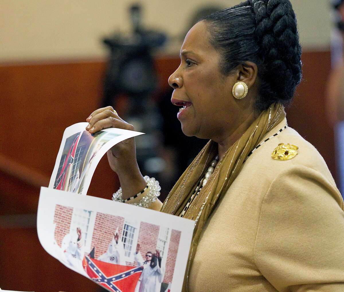 Rep. Sheila Jackson Lee holds photographs on Nov. 10, 2011, in Austin. Texas drivers won't be able to put Confederate license plates on their vehicles after a state board unanimously rejected the proposed design.