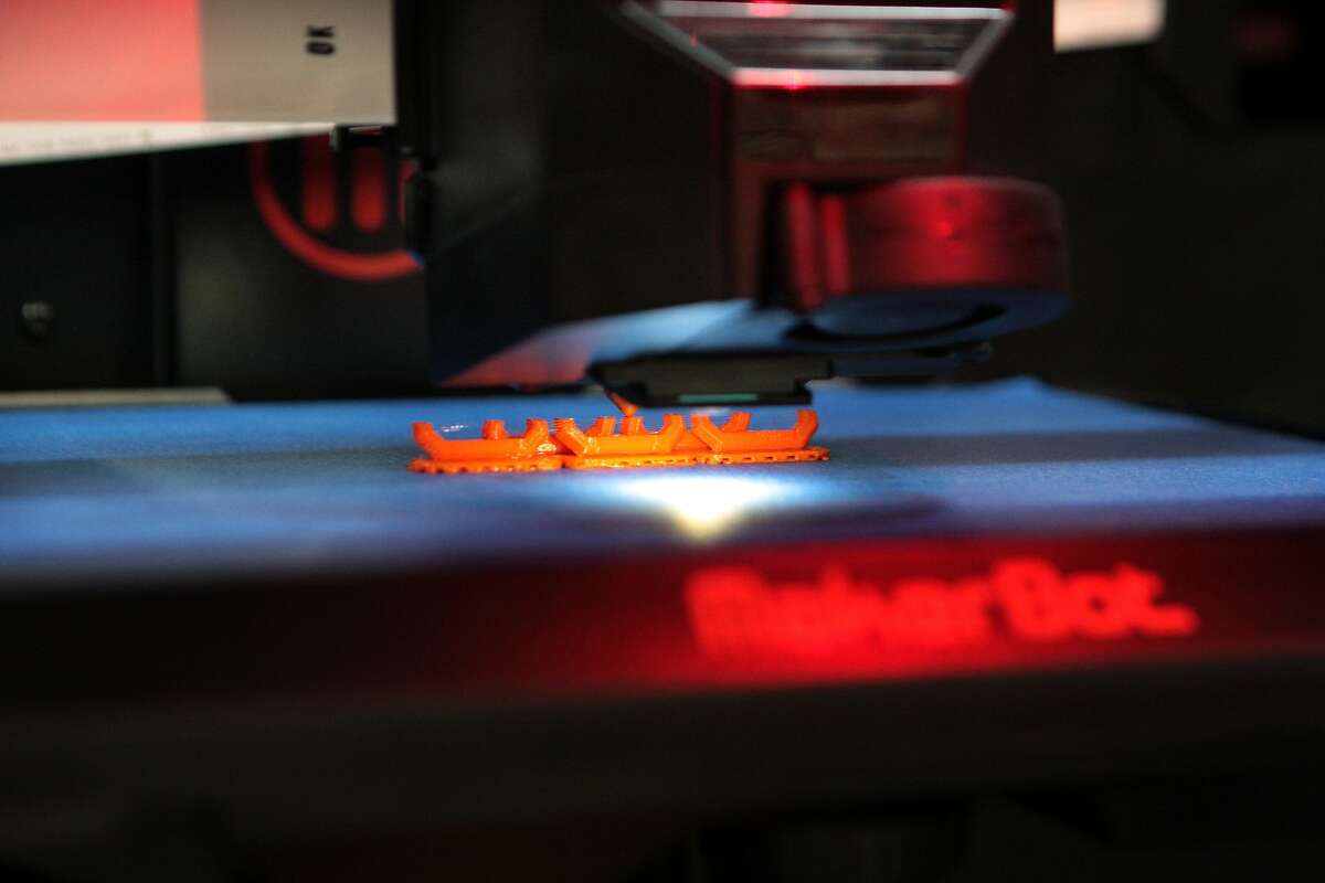 A MakerBot 3-D printer creates a small plastic chain at the Home Depot in Emeryville, Calif. on Monday, July 14, 2014. Certain branches of the home improvement chain will carry MakerBot 3-D printers nationwide, including stores in Emeryville, East Palo Alto and San Carlos.