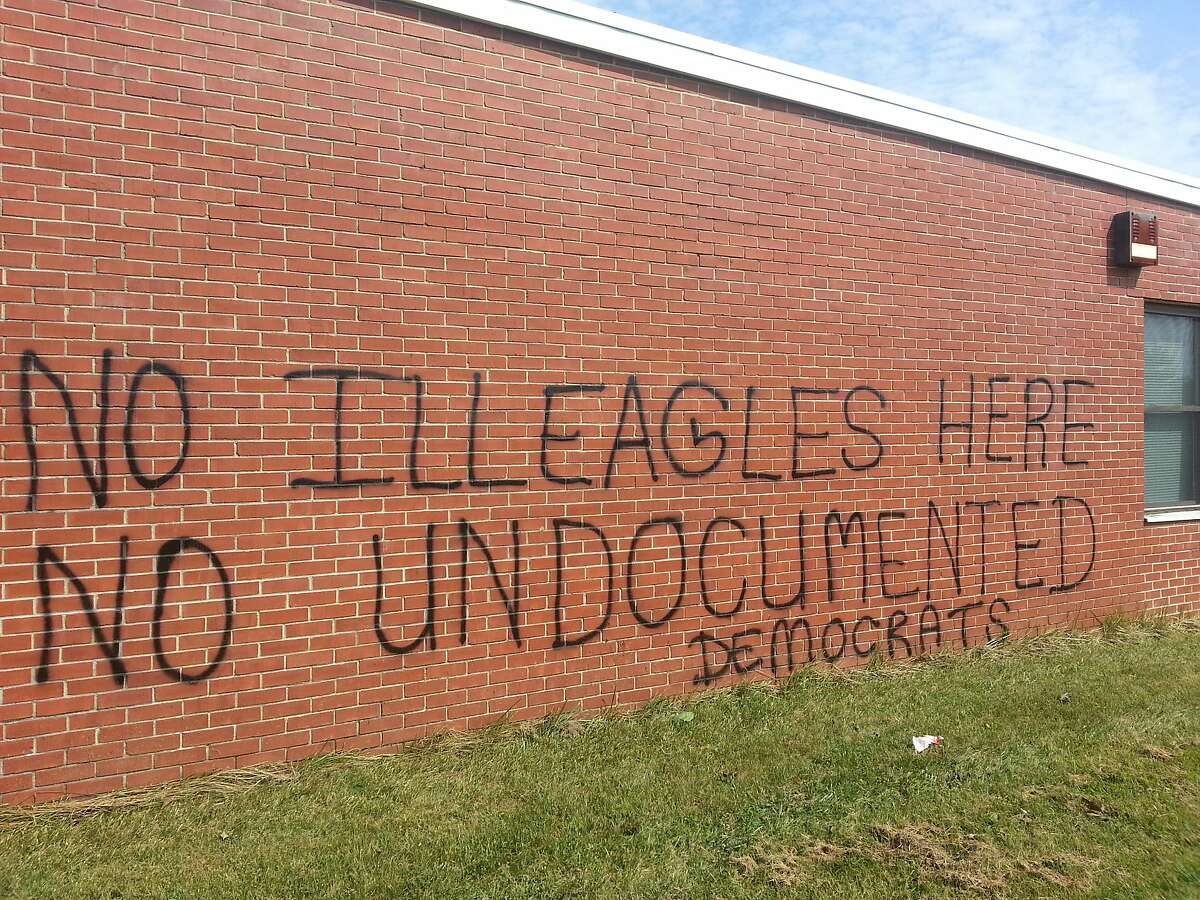 This July 14, 2014 photo shows graffiti on the side of a former Army Reserve Center in Westminster, Md. The U.S. Department of Health and Human Services considered using the building for children who cross the U.S.-Mexico border illegally, but told local officials Saturday they had dropped the idea. The Maryland State Police are investigating the graffiti, which was painted Saturday night or early Sunday, as a hate crime. (AP Photo/The Carroll County Times, Christian Alexandersen)