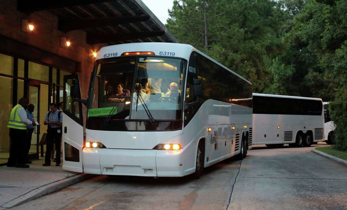 Early morning commuters get on buses Monday at the Research Park and Ride 3900 Marsico Place in The Woodlands.