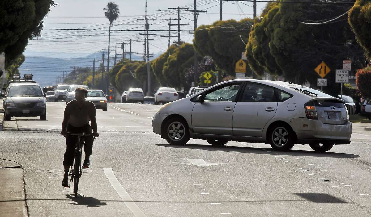 A driver waits for a bicycle to pass and avoids oncoming traffic as they make a left turn from Barrett Avenue in Richmond, Calif., onto I-80 West on Monday, July 15, 2014. The left turn from Barrett Avenue onto I-80 West can be treacherous, as the left turn is not protected by the light and faces two lanes of oncoming traffic.