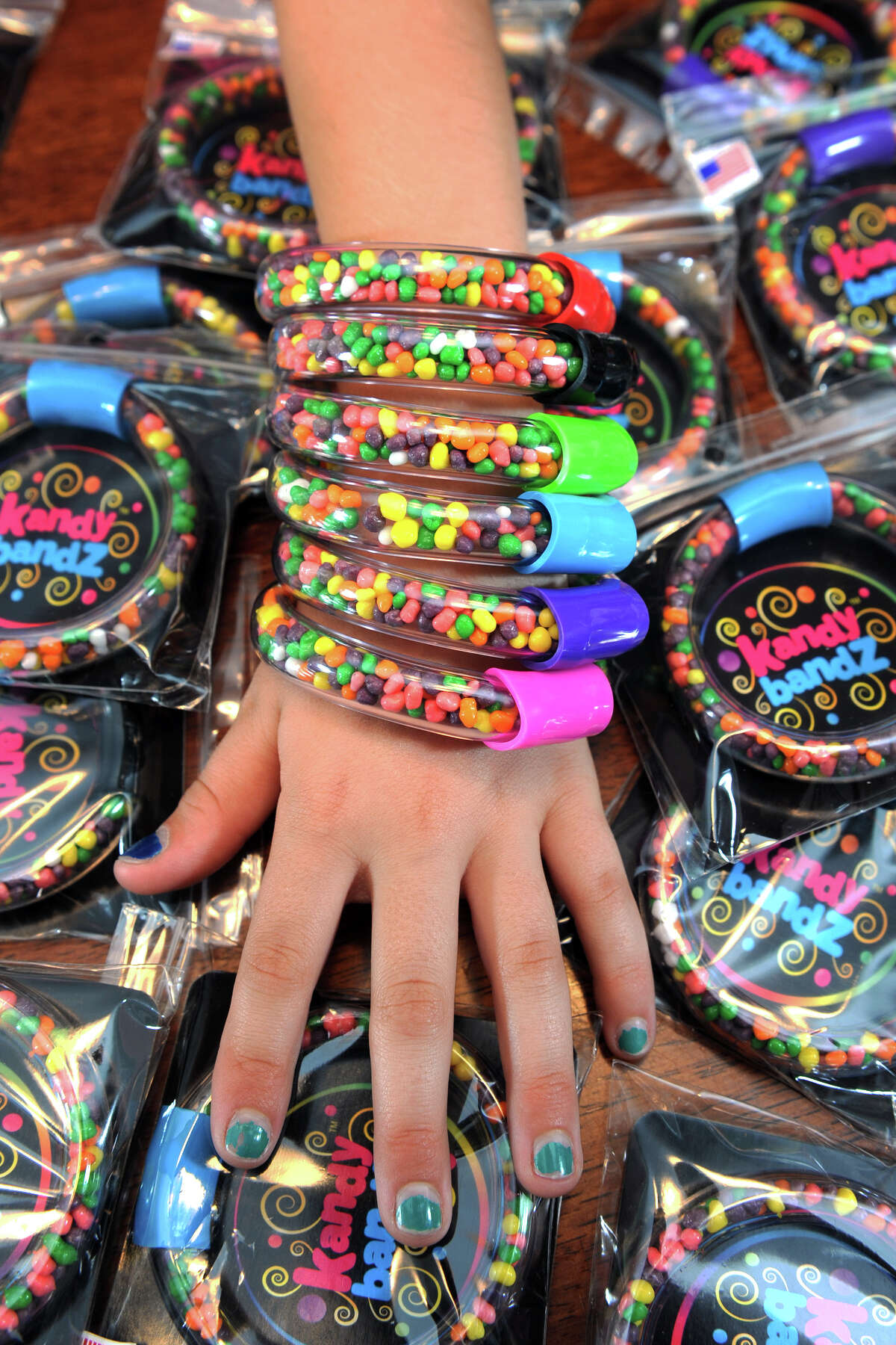 Samantha Sperrazza models several of her ìkandy bandZî, the clear plastic bracelets filled with candy that she invented and debuted at the recent Invention Convention, in Danbury, Conn. July 16, 2014. She now has a patent pending on the bracelets, which are for sale at area businesses.