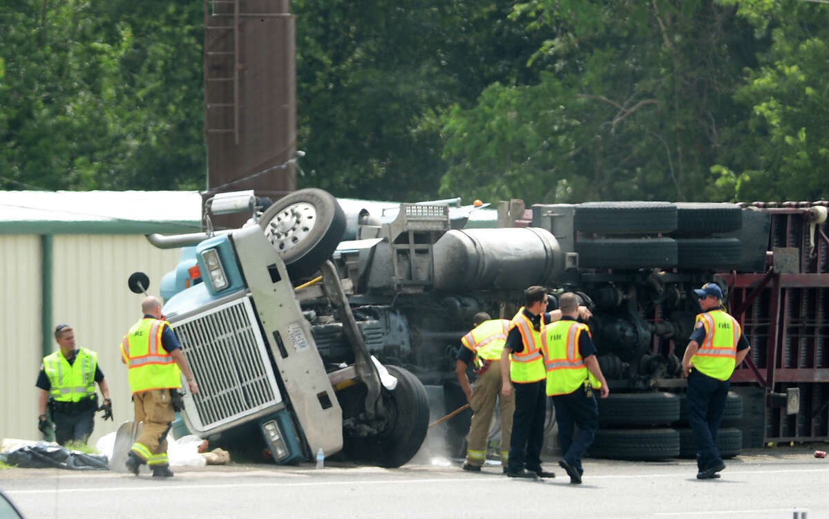 A crew works to clean up an overturned tractor trailer on Highway 69 on Wednesday. A truck carrying forklifts overturned on Highway 69 near the Martin Luther King Jr. Boulevard exit, closing down traffic for a short time Wednesday. Photo taken Wednesday 7/16/14 Jake Daniels/@JakeD_in_SETX