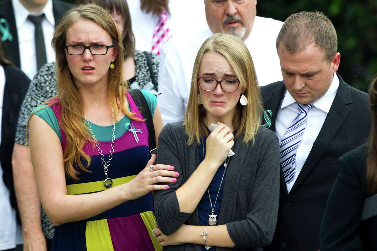 Cassidy Stay, center, the only survivor of the family massacre, leaves with other mourners after services for her parents and four siblings.