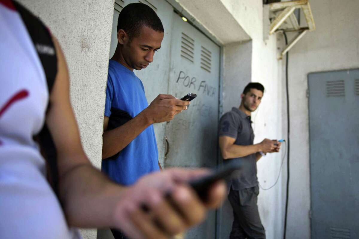 Students look for an Internet signal and possibly the “Cuban Twitter” in Cuba.