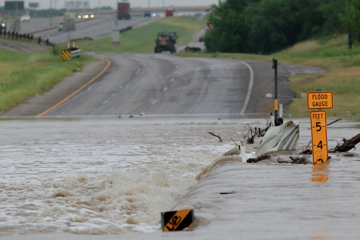 Leon Creek floods over the access road of U.S. Highway 90 west Friday July 18, 2014 after storms swept through San Antonio last night.