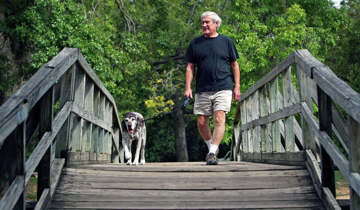 Cool dry air at Landa Park in New Braunfels provide Kermit Doerr and his dog Sedgewick a pleasant outing as they walk over a footbridge in the park. Sedgewick, a German short haired pointer, is a retired showdog.