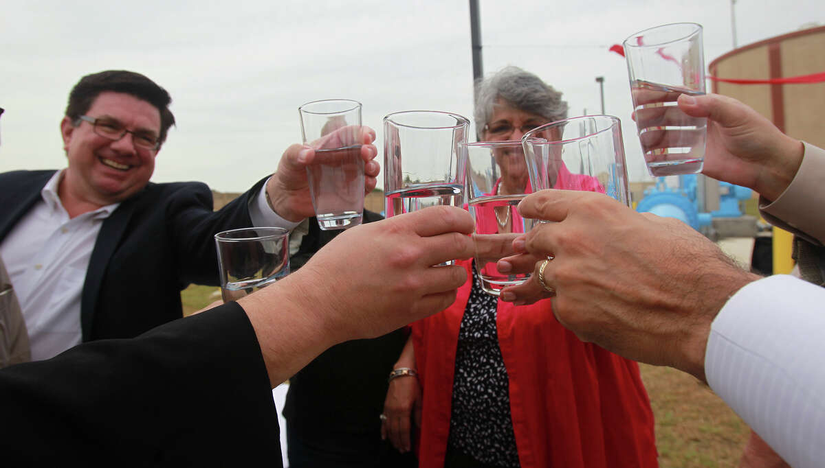 Officials from Seguin, Schertz and San Antonio celebrate with a glass of water Friday July 18, 2014 during the dedication of a SAWS pump station in Schertz, Texas that will bring water to northeast San Antonio from Gonzales County. After the water is treated at the Schertz-Seguin treatment facility, almost 5.2 billion gallons of water per year will enter SAWS pipelines and be distributed in San Antonio. On the left is Seguin City Manager Douglas Faseler.