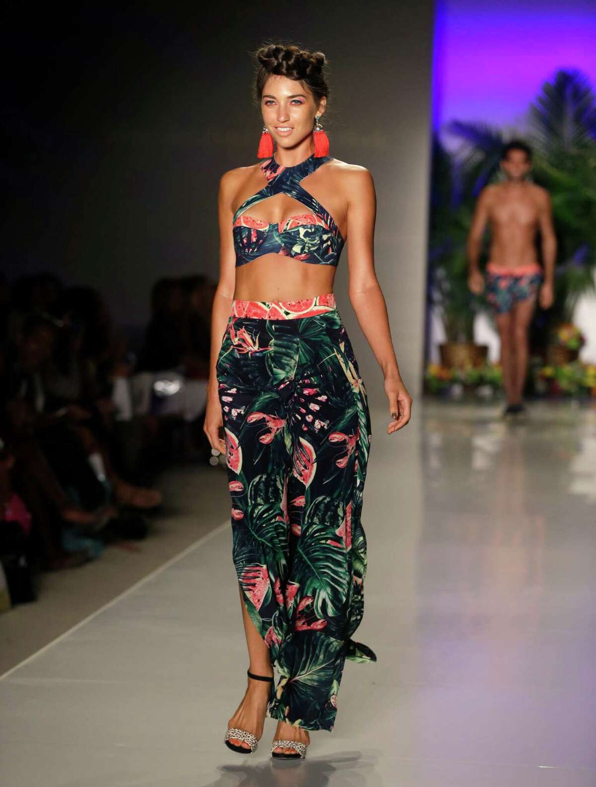 A model walks down the runway wearing swimwear designed by We Are Handsome during the Mercedes-Benz Fashion Week Swim show, Friday, July 18, 2014, in Miami Beach, Fla.