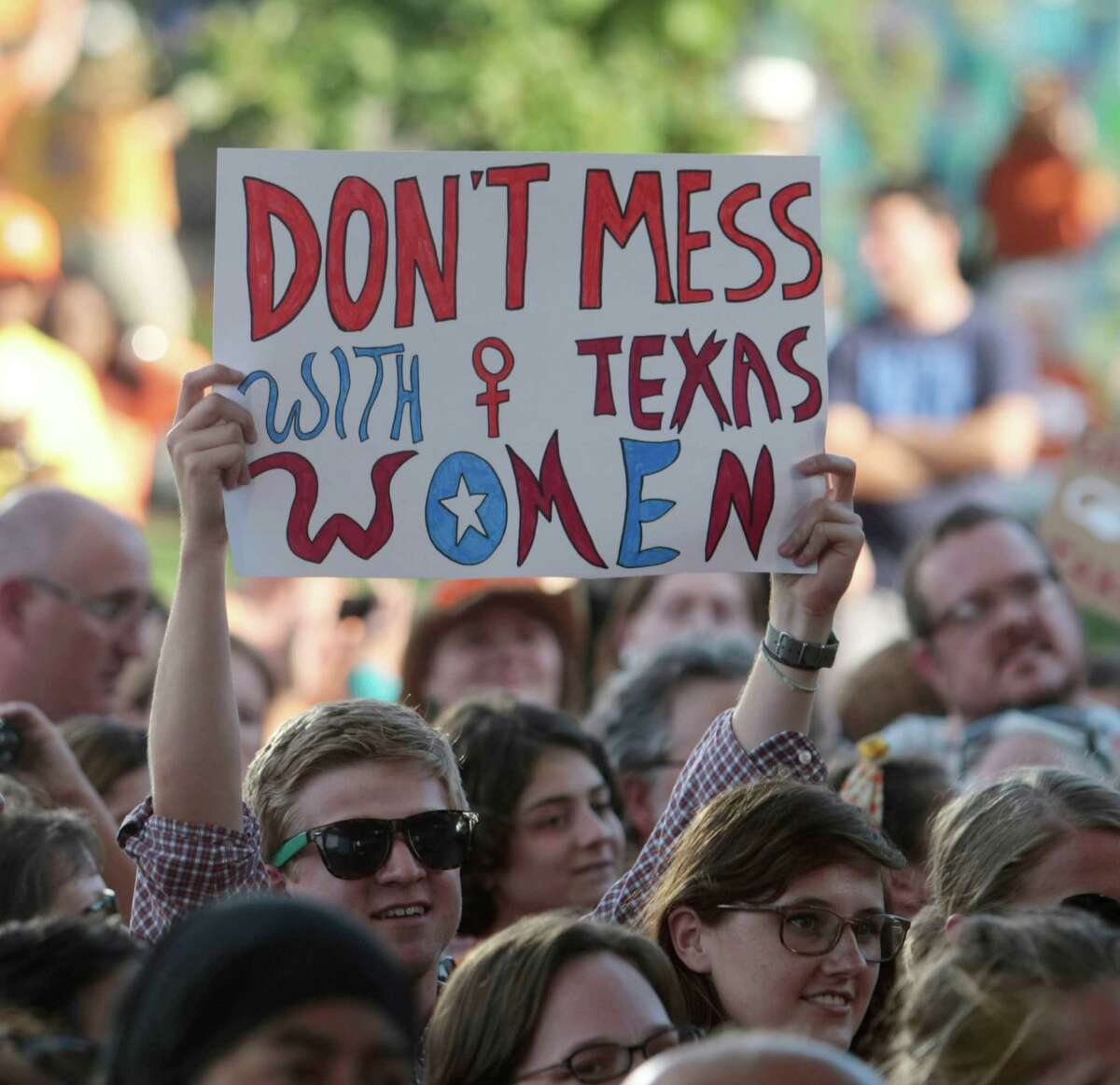 A protester holds up a sign during the Planned Parenthood Action Fund's Stand with Texas Women Rally at Discovery Green in Houston in 2013. The rally challenged an abortion restriction bill.