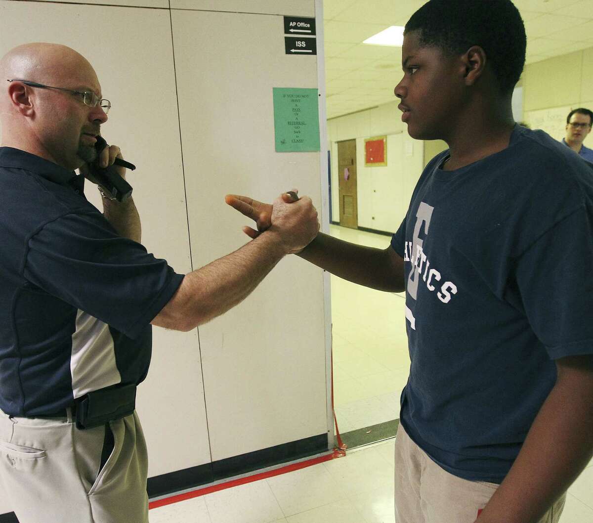 Assistant Principal Kevin Curtis (left) shakes hands with seventh-grader Kenneth Deckard, 14, at White Middle School, which uses restorative discipline.