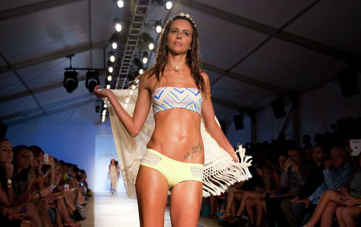 A model walks down the runway wearing swimwear from the L*Space by Monica Wise collection during the Mercedes-Benz Fashion Week Swim show, Saturday, July 19, 2014, in Miami Beach, Fla.