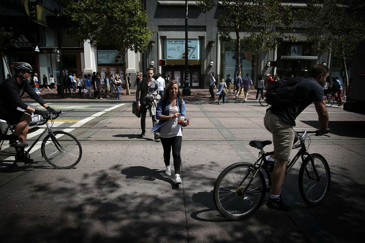 Bicyclist ride through a crosswalk as pedestrians cross the street on Friday, July 18, 2014 in San Francisco, Calif. A state appeals court says reckless-driving laws for motorists also apply to bicyclists.