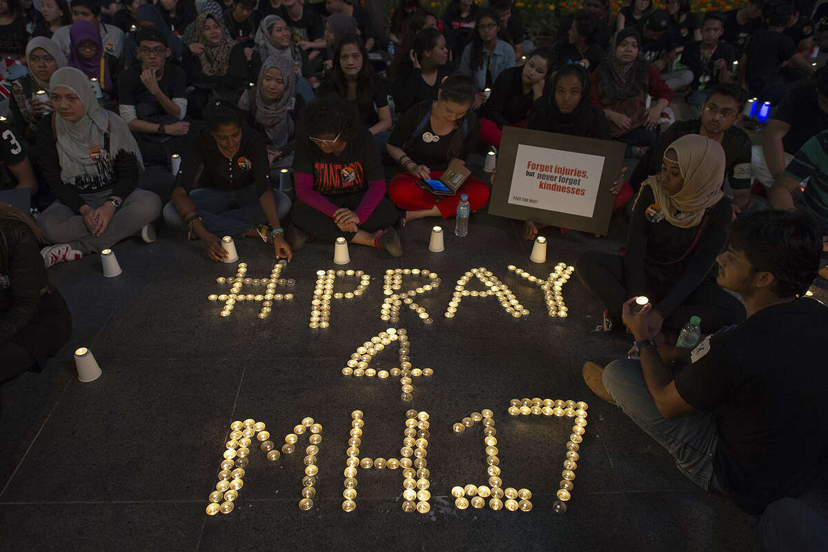 People gather during a candle-light vigil for the victims of the Malaysia Airlines flight MH17 from Amsterdam to Kuala Lumpur, at a shopping mall in Kuala Lumpur on July 18, 2014. A Malaysia Airlines Flight MH17 carrying 298 people from Amsterdam to Kuala Lumpur crashed on July 17 in rebel-held east Ukraine, as Kiev said the jet was shot down in a 'terrorist' attack.