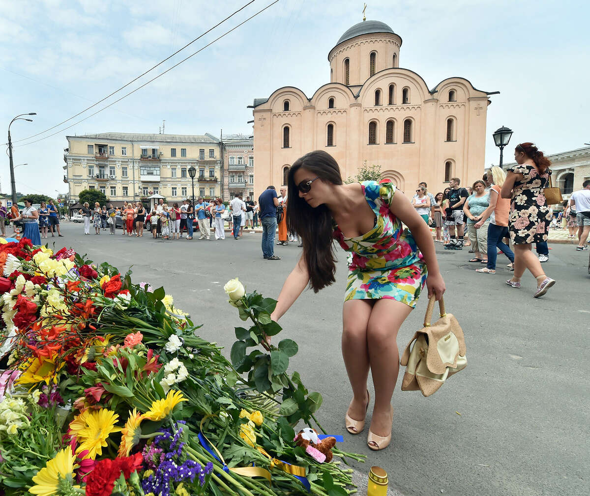 A girl lay flowers as people lay flowers and light candles in front of the Embassy of the Netherlands in Kiev on July 18, 2014, to commemorate passengers of Malaysia Airlines flight MH17 carrying 295 people from Amsterdam to Kuala Lumpur which crashed in eastern Ukraine. Ukraine's prime minister said Friday that pro-Russian separatist rebels that Kiev believes shot down a Malaysian airliner with 298 people on board should face an international tribunal The Hague.