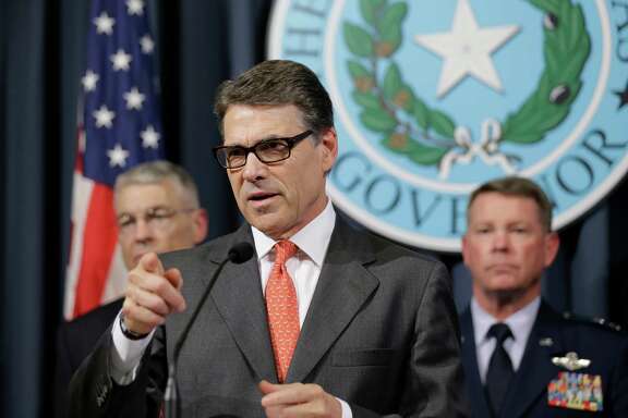 Gov. Rick Perry, center, speaks during a news conference in the Governor's press room, Monday, July 21, 2014, in Austin, Texas. Gov. Perry announced he is deploying up to 1,000 National Guard troops over the next month to the Texas-Mexico border to combat criminals that Republican state leaders say are exploiting a surge of children and families entering the U.S. illegally.  (AP Photo/Eric Gay)