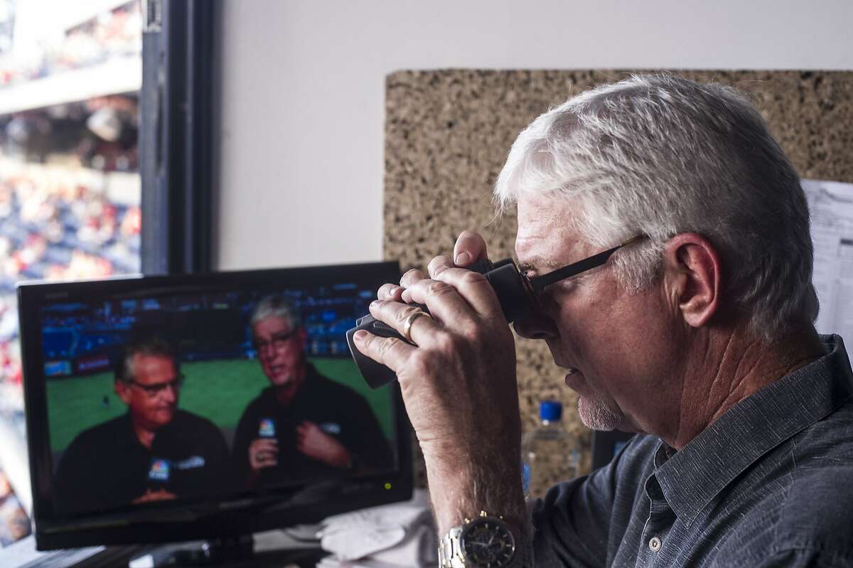 Mike Krukow, long-time television color commentator for the San Francisco Giants, looks through binoculars before the start of the game at Citizen's Bank Park in Philadelphia, PA, on July 21, 2014.