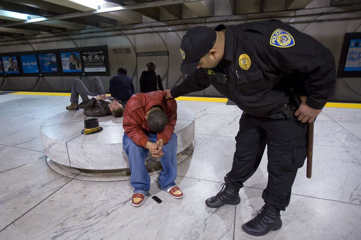 BART police officer Jesse Sekhon, right, tries to wake a sleeping New Years reveler at Embarcadero Station in downtown San Francisco, Calif. on Friday, Jan. 1, 2010, before the last train leaves after 3 a.m. Increased police and security presence at local BART stations led to a relatively calm New Years.