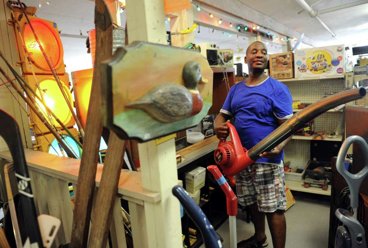 Jabu Lani, of Derby, checks out the items for sale at 1-800-Mr-Junker Wednesday, July 23, 2014, at the shop in Derby, Conn. The junk removal and hauling service sells 80 percent of hauled away items at their outlet store in Derby. Lani stops in every week or two, he said, looking for tools mostly but also to check out new inventory.