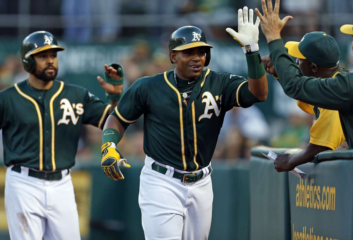 Oakland Athletics' Yoenis Cespedes and Coco Crisp celebrate Cespedes' 3-run home run in 2nd inning against Houston Astros' Brad Peacock during MLB game at O.co Coliseum in Oakland, Calif. on Wednesday, July 23, 2014.