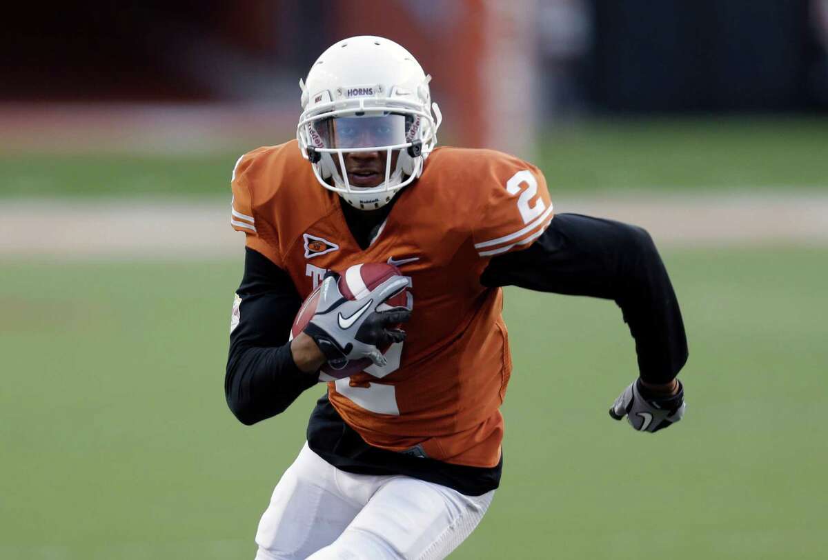 FILE - In this March 30, 2013 file photo, University of Texas football player Kendall Sanders (2) carries the ball during the team's spring football game in Austin, Texas. A University of Texas police spokeswoman says two Longhorns football players have been charged with felony sexual assault and their arrests are pending. Spokeswoman Cindy Posey says the players charged Thursday, July 24, 2014, are wide receivers Kendall Sanders and Montrel Meander.