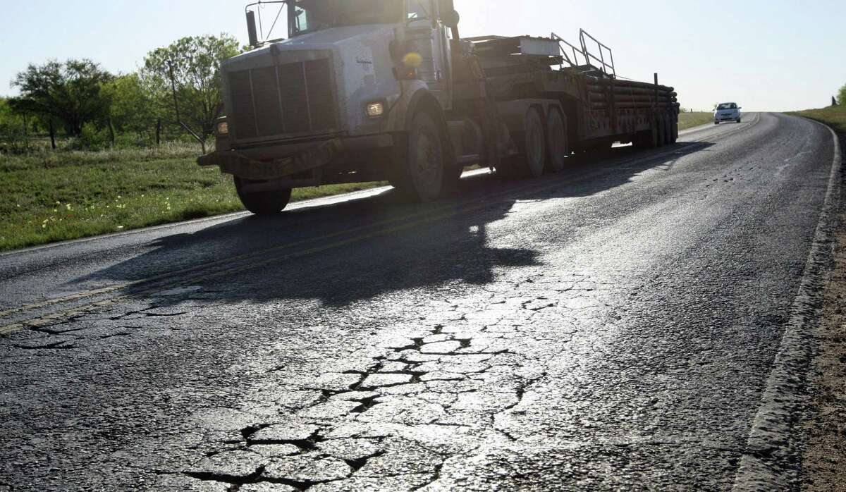 Oil field traffic moves along FM 468 just northwest of Cotulla. La Salle County and other top oil-producing areas in the Eagle Ford Shale are dealing with road problems including broken chunks of shoulders, potholes and “alligator” cracks.