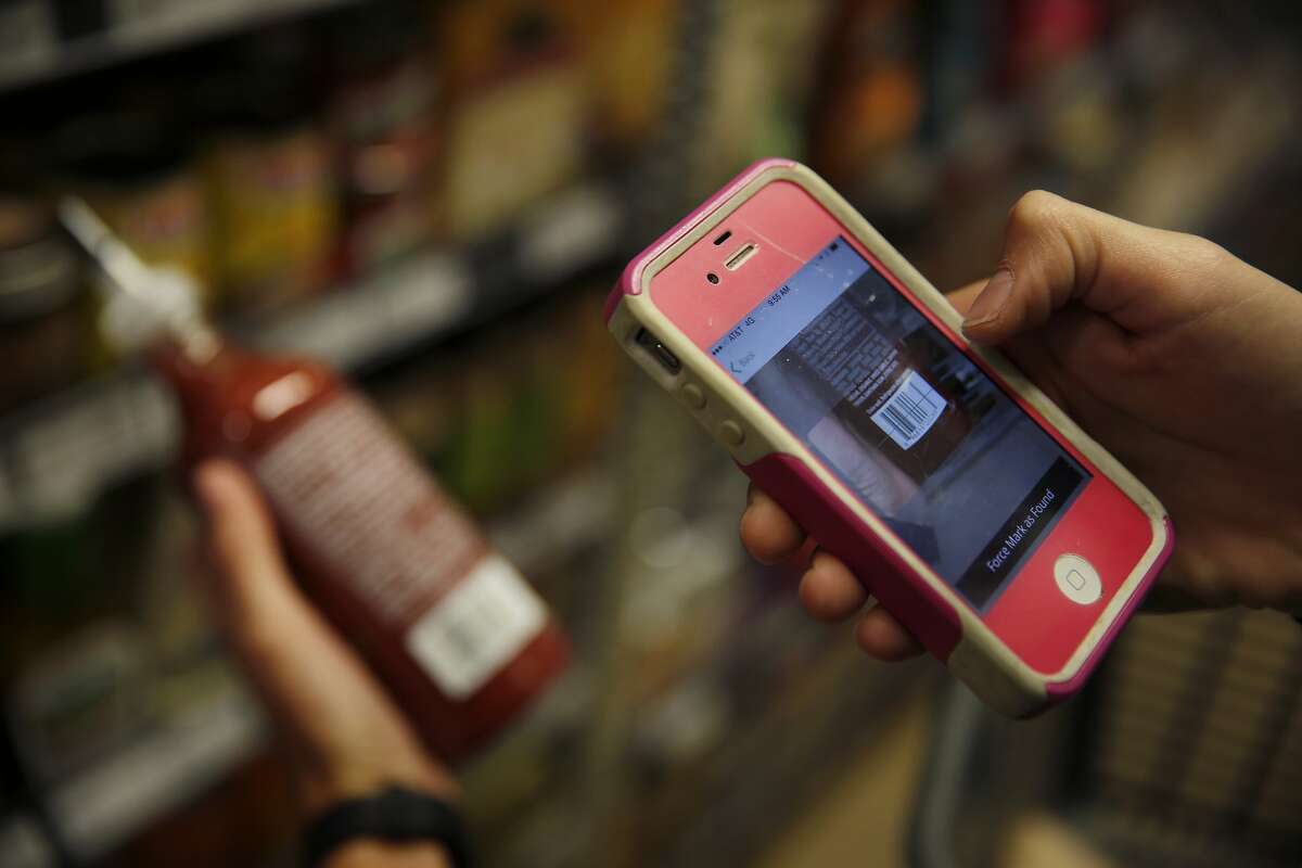 Instacart personal shopper, Sydney Hollingsworth, scans the UPC code on a product as she fills a customer's order at the Bi-Rite Market on Divisadero Street on Thursday, July 24, 2014 in San Francisco, Calif.