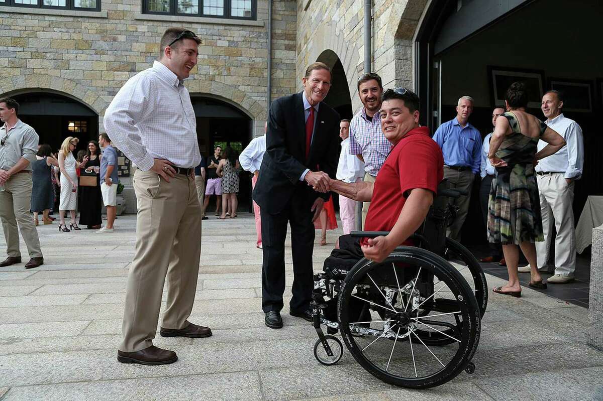 Nine Line Foundation founders Danny Merritt and Tyler Merritt look on as Senator Richard Blumenthal shakes hands with Green Beret Sergeant First Class Mark Holbert, honoree at the foundation's Vets Helping Vets fundraiser, which was held last week at the Greenwich home of Steven and Dana Steinman.