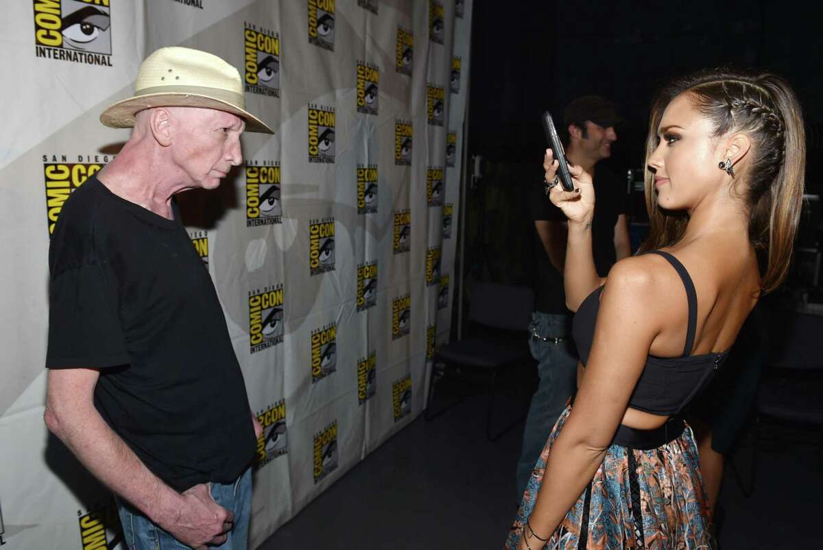 IMAGE DISTRIBUTED FOR DIMENSION FILMS - Jessica Alba, right, takes a photo of writer Frank Miller as they arrive at the "Sin City: A Dame to Kill For" press line on Day 3 of Comic-Con International on Saturday, July 26, 2014, in San Diego.