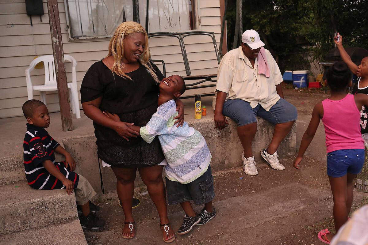 Tamika Winn is embraced by son, Trezvant Mason, 7, as they spend the evening with family at the East Side home owned by Winn's grandmother, Gloria Nelson.