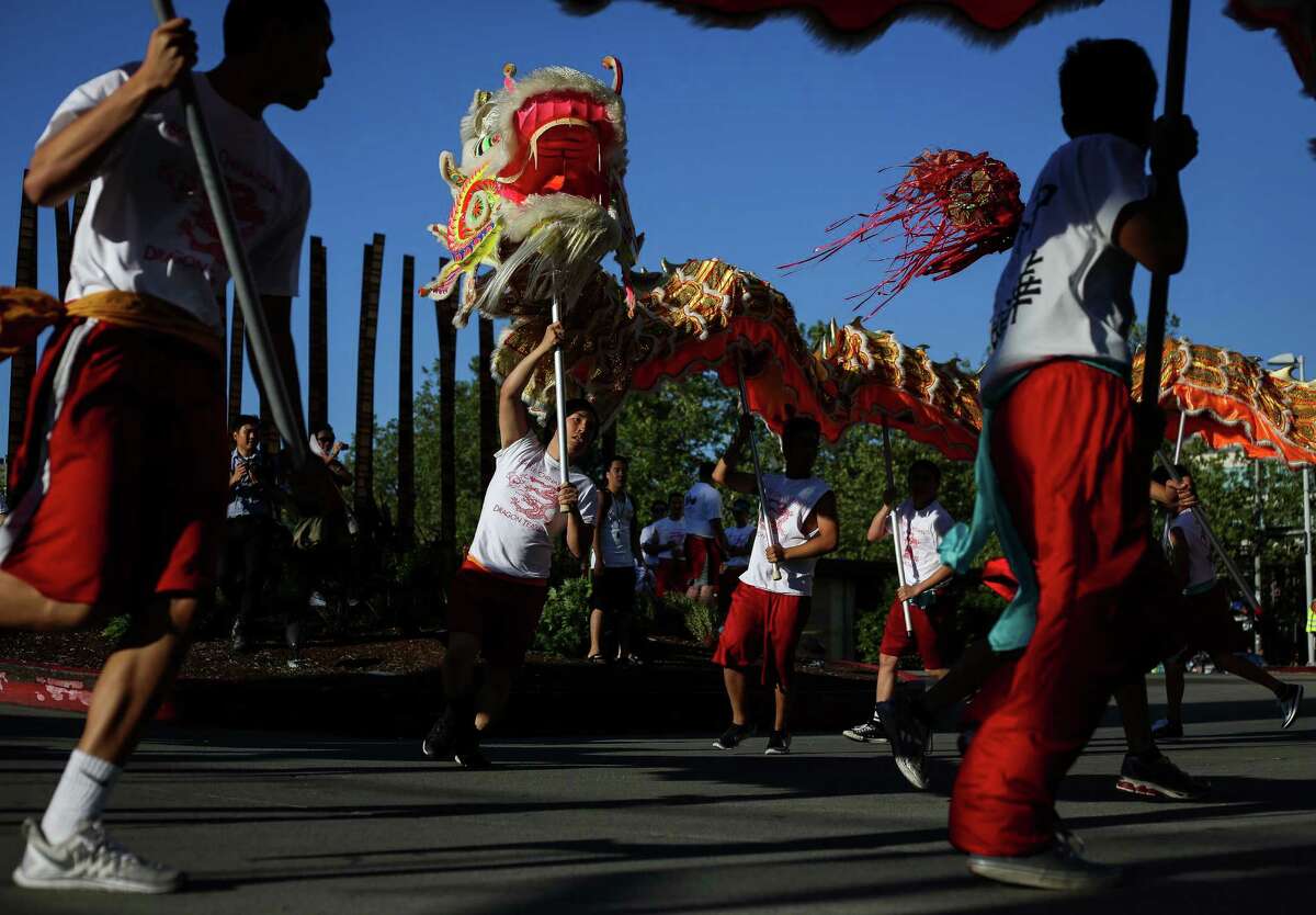 The 100-foot dragon weaves through a parking lot prior to the Alaska Airlines Seafair Torchlight Parade on Saturday, July 26, 2014. Thousands lined the streets to watch the parade which featured drill teams, marching bands, pirates, floats, and Sounders players Clint Dempsey and DeAndre Yedlin.