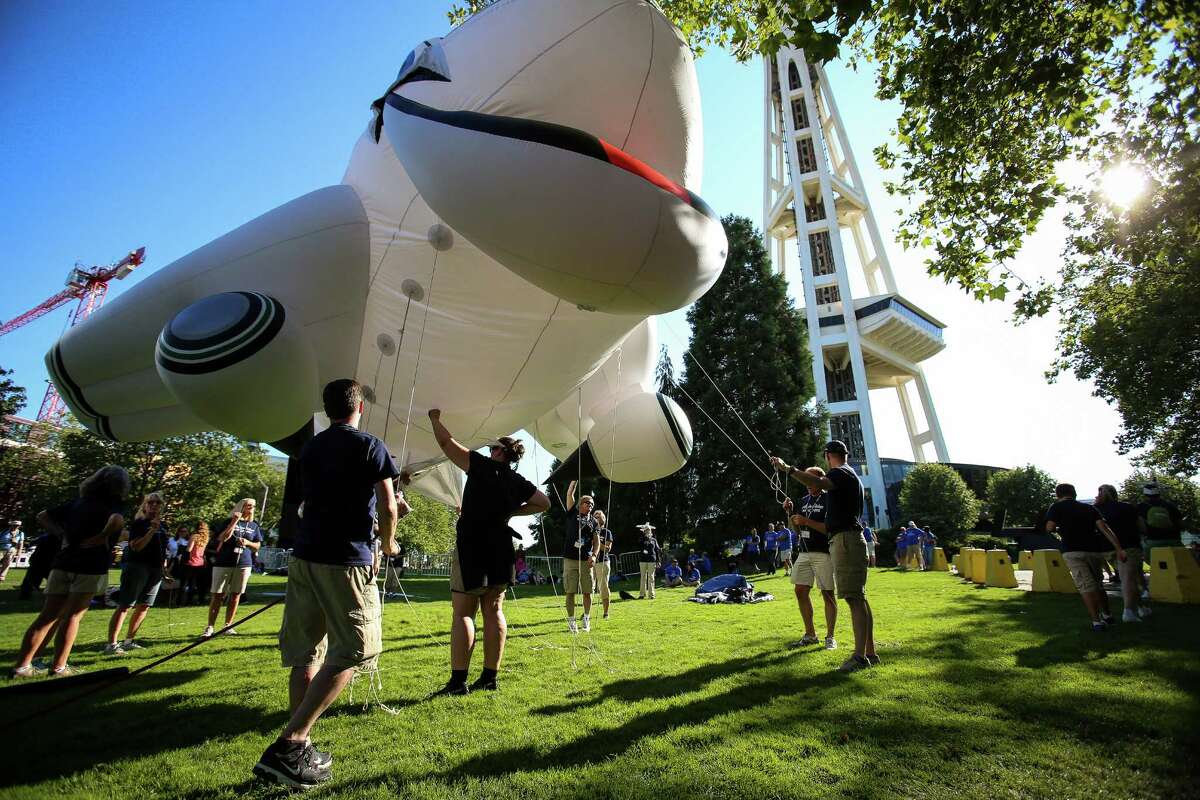 People ready a giant balloon prior to the Alaska Airlines Seafair Torchlight Parade on Saturday, July 26, 2014. Thousands lined the streets to watch the parade which featured drill teams, marching bands, pirates, floats, and Sounders players Clint Dempsey and DeAndre Yedlin.