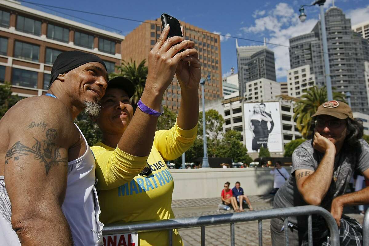 Ronnie Goodman takes a photo with Darice Caudle after finishing the San Francisco Marathon on Sunday, July 27, 2014 in San Francisco, Calif. Goodman is a homeless artist who lives in a tent under the freeway who has long dreamed of running in the marathon.