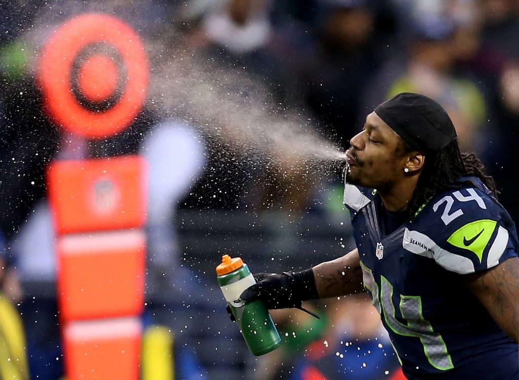 Seattle Seahawks running back Marshawn Lynch (24) dons his gloves during an  injury time out during the NFL Championship Game against the San Francisco  49ers at CenturyLink Field in Seattle, Washington on