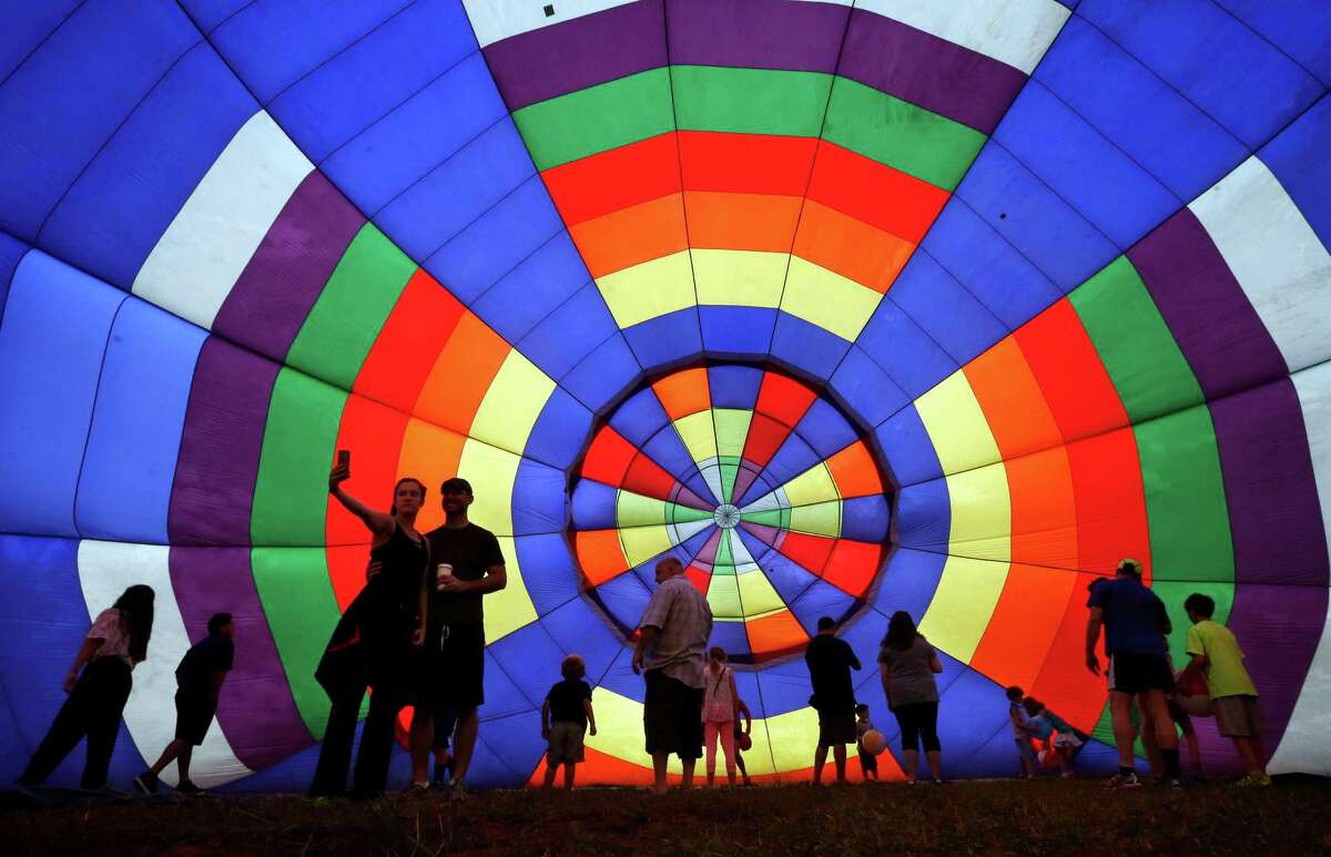 People walk around inside a partially inflated hot air balloon at the 32nd annual OuickChek New Jersey Festival of Ballooning, Sunday, July 27, 2014, in Readington, N.J. 