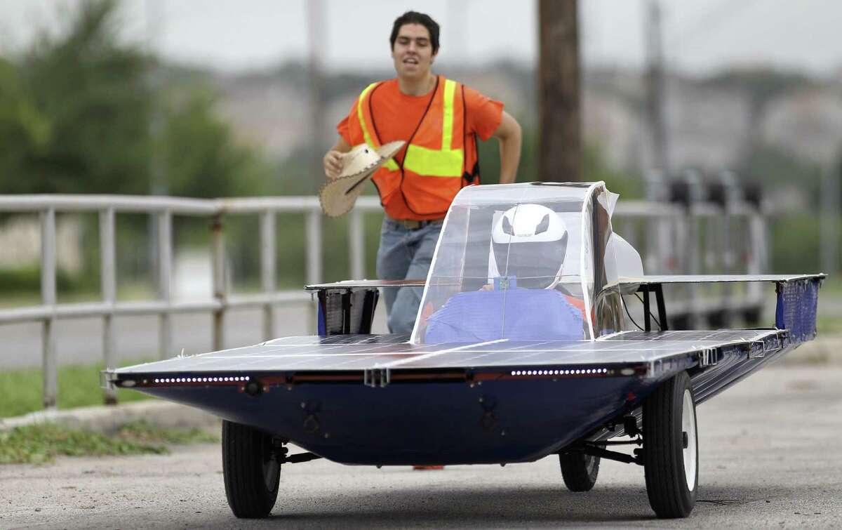 David Castro, 18, back, runs after the solar car Helios 2, driven by Ricardo Sanchez, 17, at a test drive at Madison High School. The car built by Madison students competed in this year's Solar Car Challenge in Fort Worth.