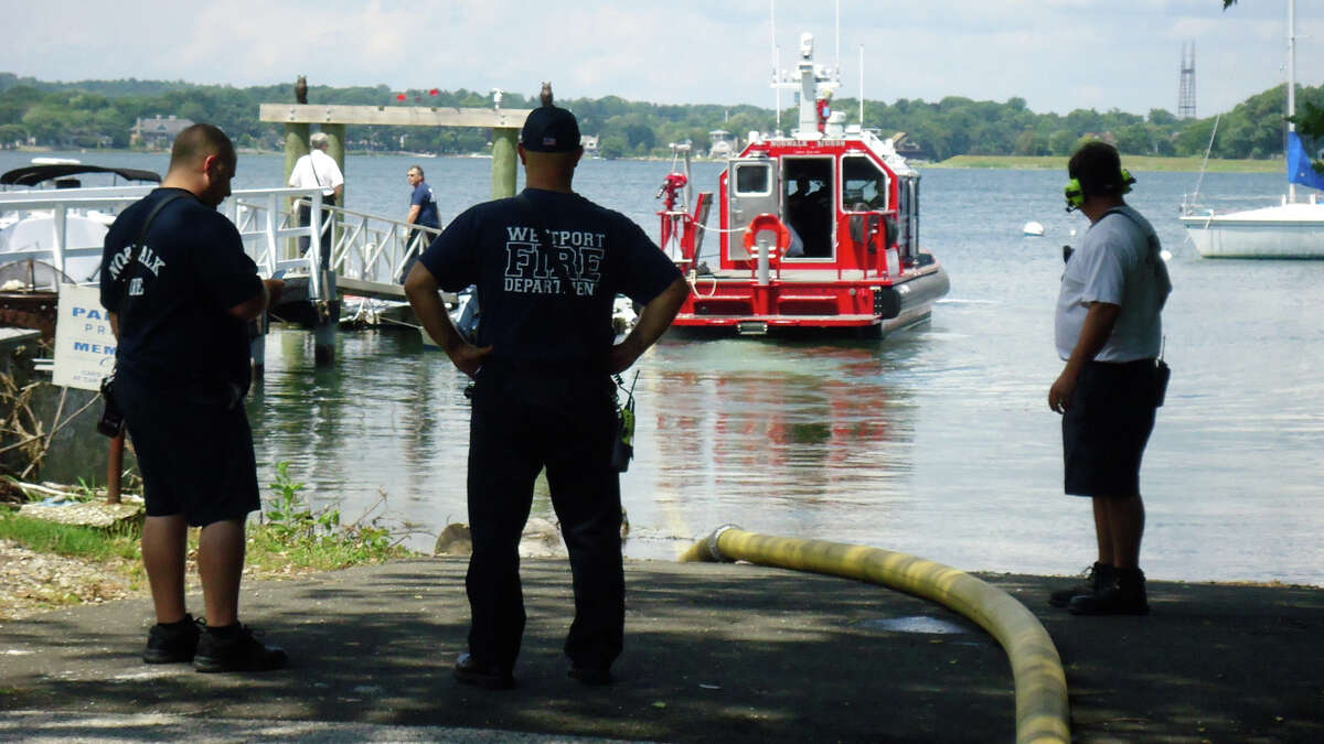 Firefighters monitor the water-supply hose attached to Norwalk's fire boat during a shoreline fire training drill Monday.