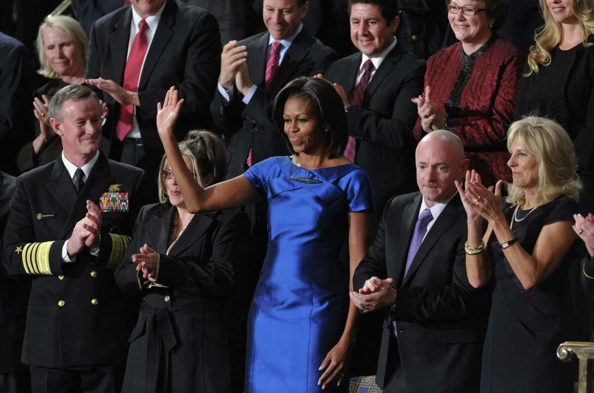 US First Lady Michelle Obama (R) waves from the gallery of the US House of Representatives prior to US President Barack Obama's State of the Union address on January 24, 2012 on Capitol Hill in Washington, DC. From left are: Admiral William McRaven; Jackie Bray; Michelle Obama; US astronaut Mark Kelly, husband of shot US Rep. Gabrielle Giffords; Dr. Jill Biden, wife of US Vice President Joe Biden; and Ashleigh Berg. AFP PHOTO / Mandel NGAN