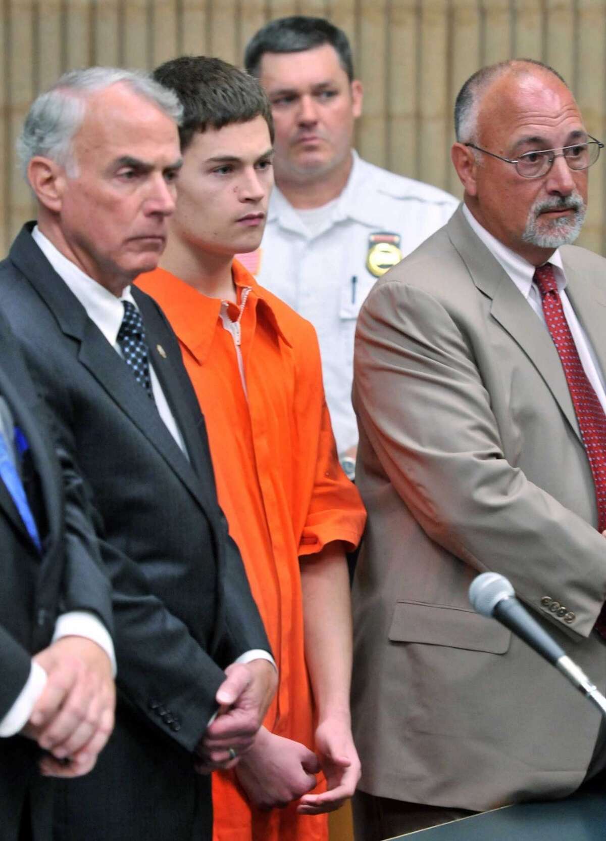 Christopher Plaskon, 18, second from left, appears in Superior Court in Milford, Conn., on Wednesday, June 4, 2014. Plaskon, charged with stabbing a classmate to death in school on their prom day, pleaded not guilty to murder Wednesday as his attorney said he was investigating a possible mental health defense. At left is Plaskon's uncle and guardian Paul Healy, and attorney Richard Meehan Jr., stands at right.