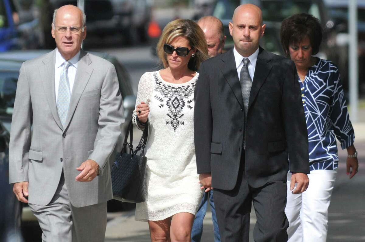 Troy police officer Brian Gross, right, is escorted into Troy City Court by his wife, center, and attorney Stephen Coffey, left, Wednesday, July, 30, 2014, in Troy N.Y. Officer Gross has been charged with felony evidence tampering and other charges for allegedly tipping off a suspect about an impending raid by a State Police narcotics squad. (Cindy Schultz/Times Union)