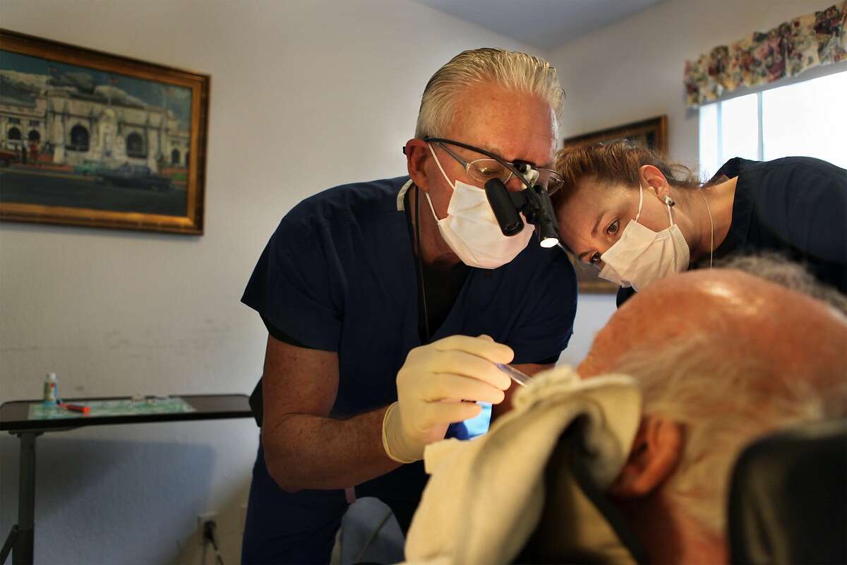 Dr. David Blende and Victoria Cameron, registered dental asistant, doing a check up on a patient in his room at Burlingame Villa on Tuesday, February 23, 2010. Bay Area House Call Dentists provide in house basic dental care mainly for seniors.