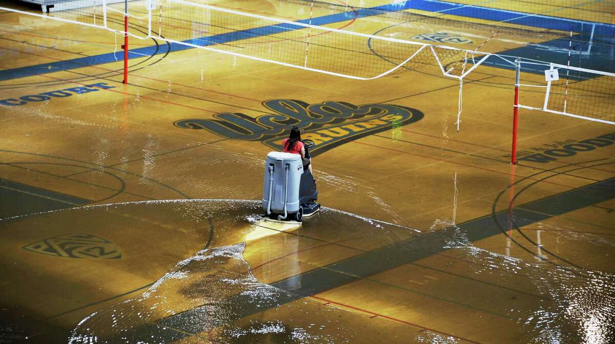 Some of the 10 inches of water that covered the court at UCLA's Pauley Pavilion when a water main broke is removed. Kim Schmaader, in charge of campus facilities said the court is buckling, but the school was still working to save it.