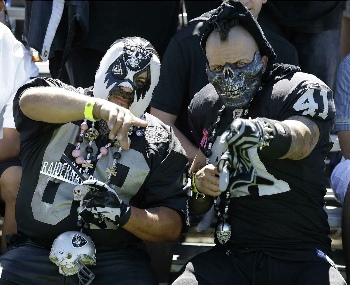 Oakland Raiders fans gesture on the sidelines during their NFL football training camp Saturday, July 26, 2014, in Napa, Calif. (AP Photo/Eric Risberg)