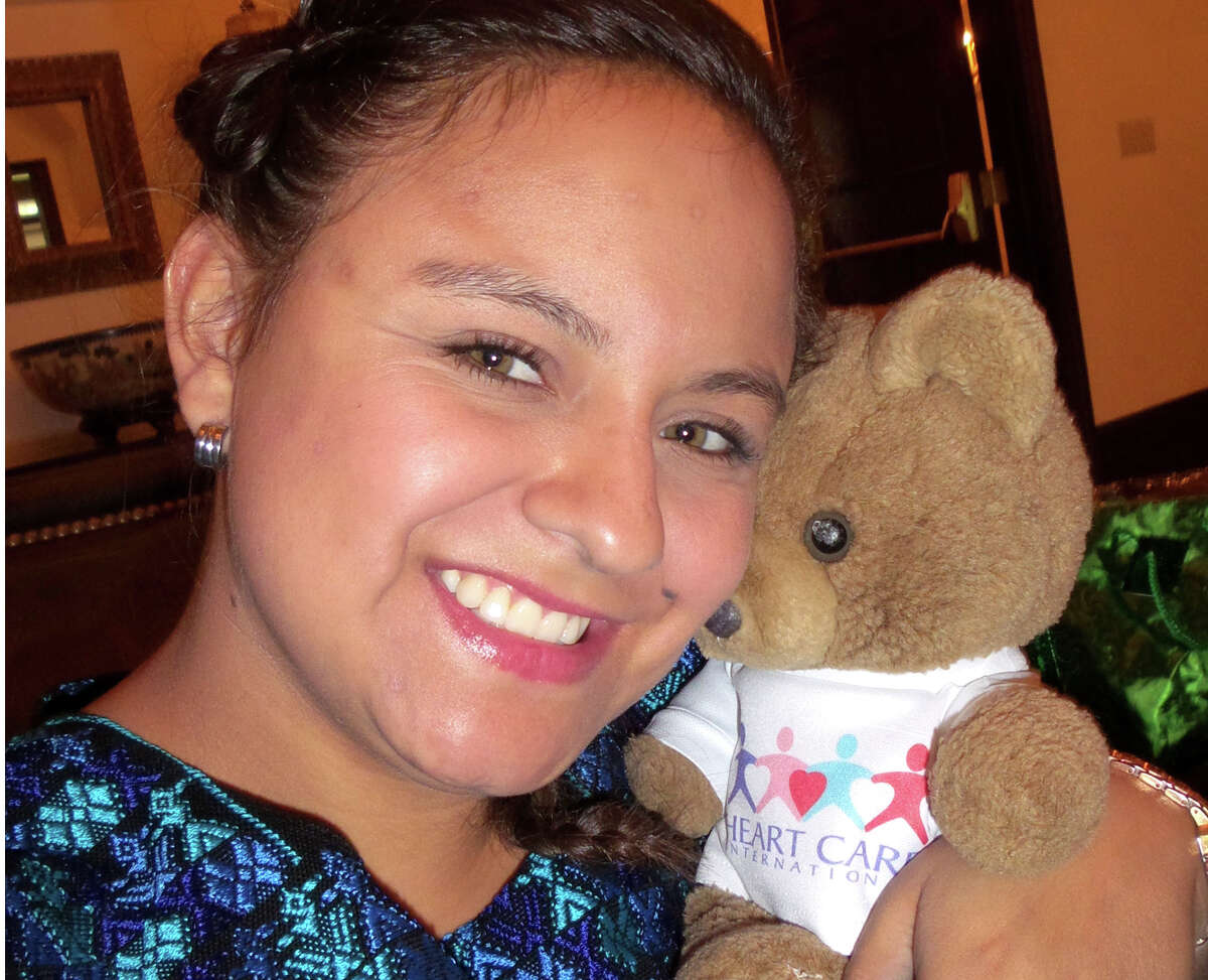 Claudia Maria Sarai Tujab hugs her teddy bear given to her at the the time of her heart surgery 19 years ago by a Heart Care International (HCI) medical team. Tujab says her teddy bear has been adopted by her little sister Melanie.