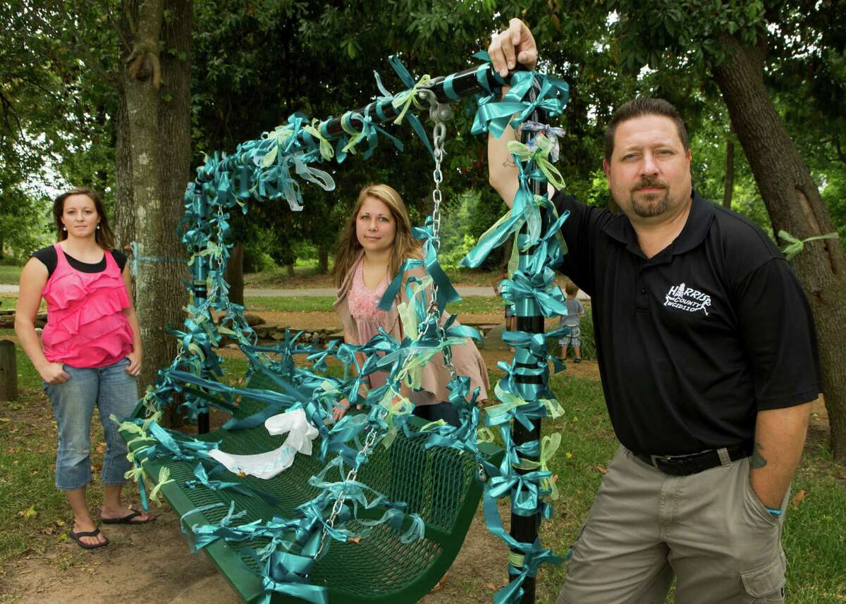 Beckie Taylor, left, Aly Smith and Jody Dellinger pose for a photo near a ribbon-adorned swing in Forest Oaks Park on Tuesday, July 29, 2014, in Spring. Taylor, Smith and Dellinger have been instrumental in fund raising efforts to help Cassidy Stay, whose family was killed in a mass shooting in their Spring home. The swing is where a photo of the Stay family was taken. ( Brett Coomer / Houston Chronicle )