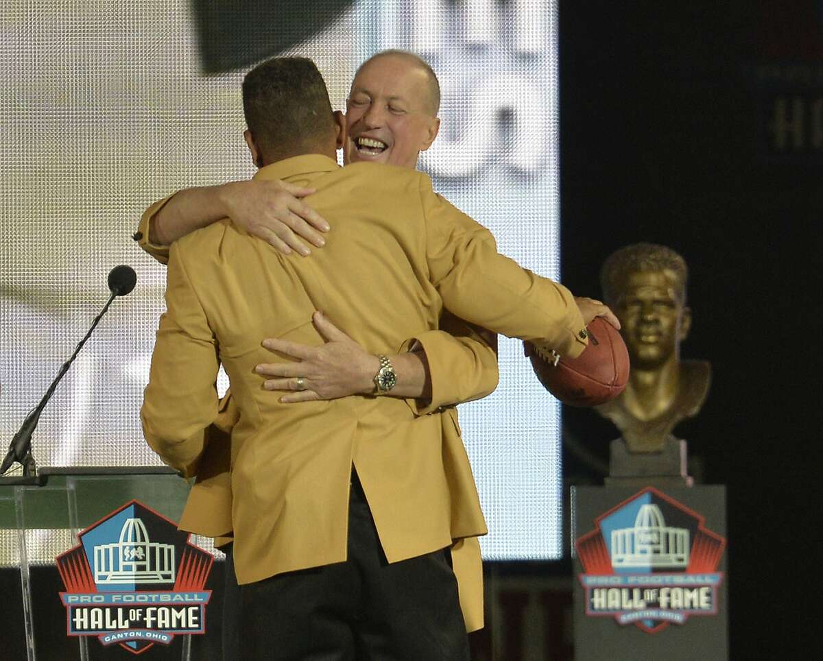 Former Buffalo Bills quarterback Jim Kelly, back, hugs inductee Andre Reed during the Pro Football Hall of Fame enshrinement ceremony Saturday, Aug. 2, 2014, in Canton, Ohio. (AP Photo/David Richard)