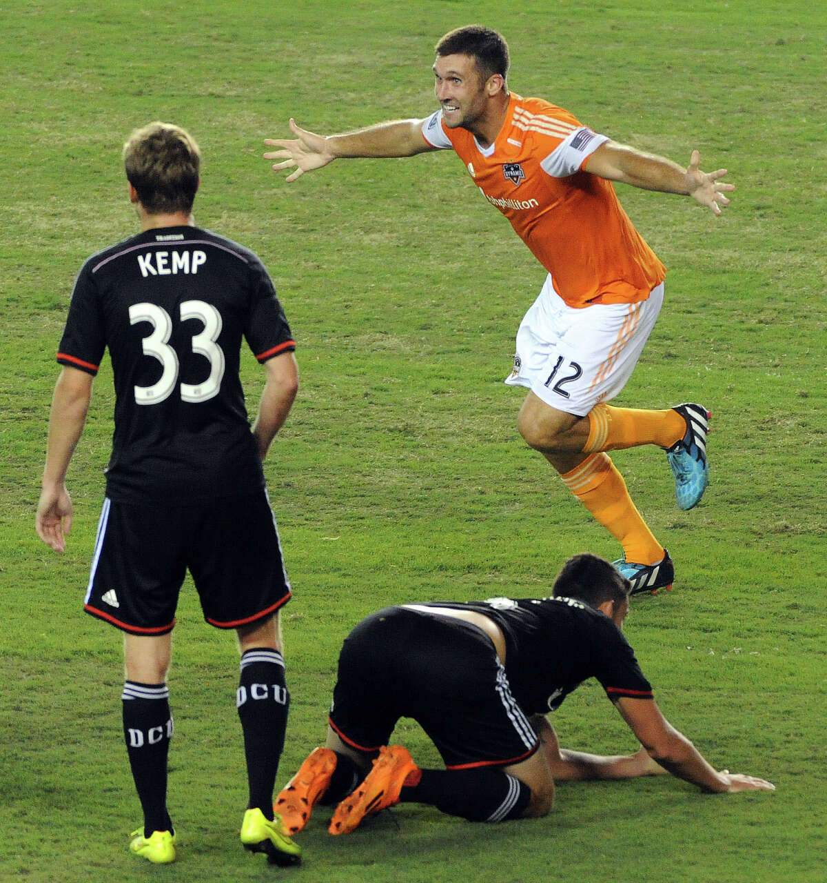 Houston Dynamo forward Will Bruin (12) celebrates his game-winning goal in the 90th minute as D.C. United defender Taylor Kemp (33) looks on during the second half of an MLS soccer game , Sunday, August 3, 2014, at BBVA Compass Stadium in Houston.