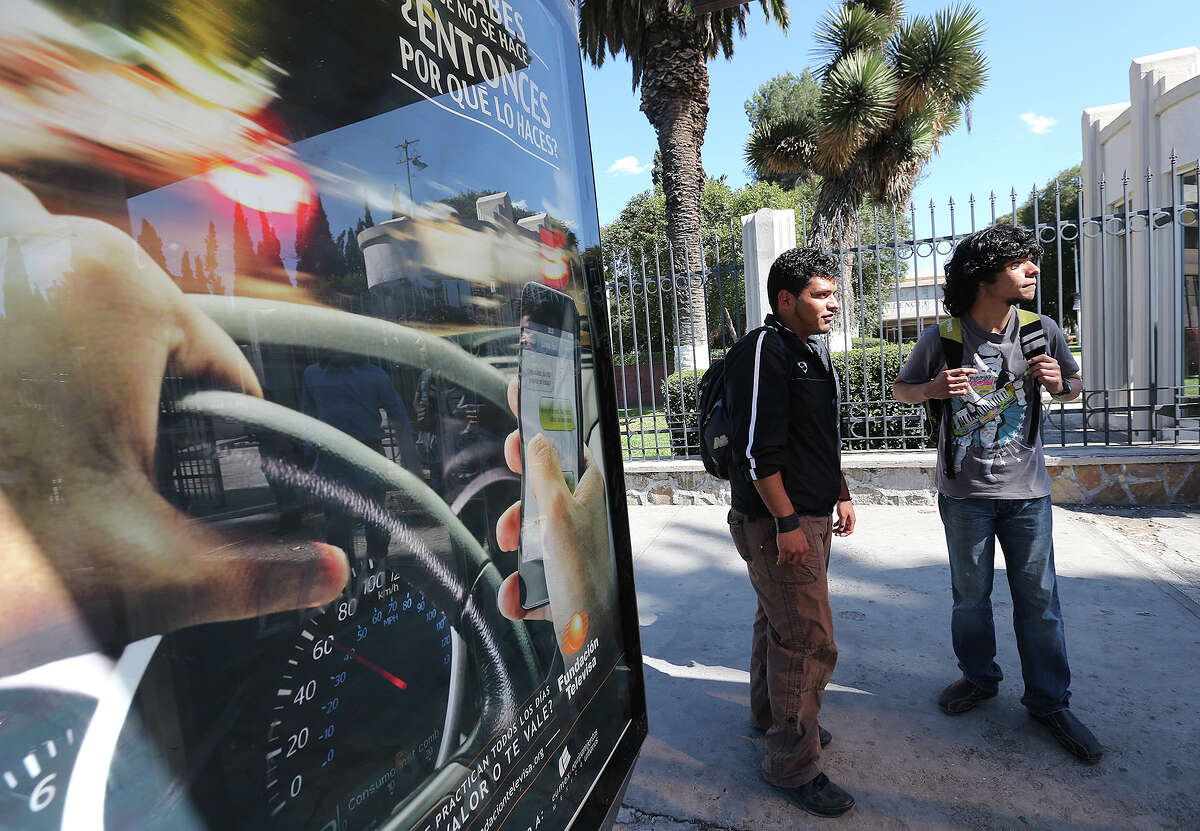 Universidad Autonoma de Coahuila engineer students Mario Galindo, 19, left, and Abraham Fabian, 19, wait for the bus in Saltillo, Mexico, Wednesday, Feb. 19, 2014. The state is under an almost $3 billion debt incurred by the former administration of Governor Humberto Moreira.